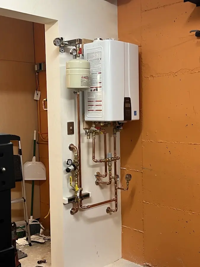 Plumbing technician inspecting water heater connections in Lisle